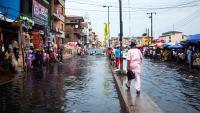 People walk down a heavily flooded market street in Lagos, Nigeria