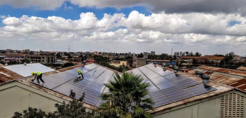 People working on rooftop solar panels